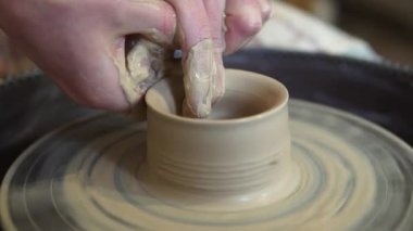 Potter bükülmüş çömlek tekerinde seramik demlik yapıyor. Potter iş yerinde, kapat..