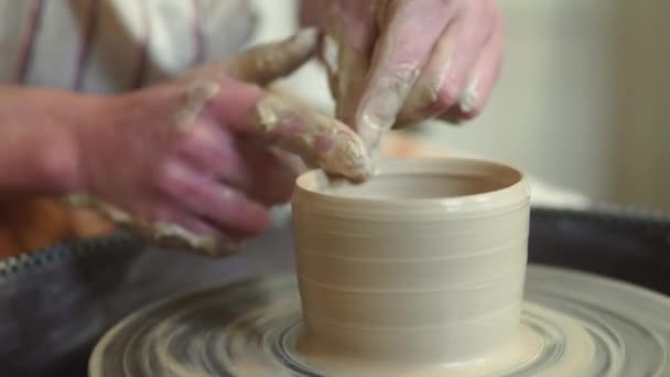 Potter haciendo olla de cerámica en la rueda de cerámica retorcida. Potter en el trabajo, de cerca. — Vídeo de stock