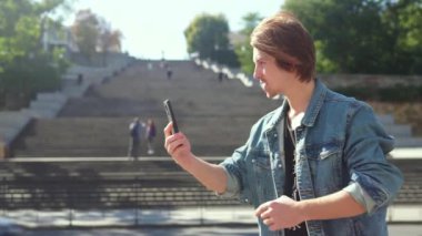 Adam video görüşmesiyle konuşuyor. Büyük bir merdivenin arkaplanı