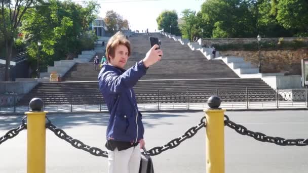 Le gars parle par appel vidéo. fond d'un grand escalier — Video