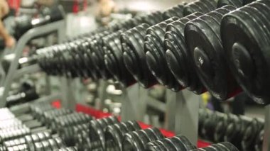 Halterli raflar. Spor ekipmanlarına yakın çekim. Spor salonu. El kameralı atış.