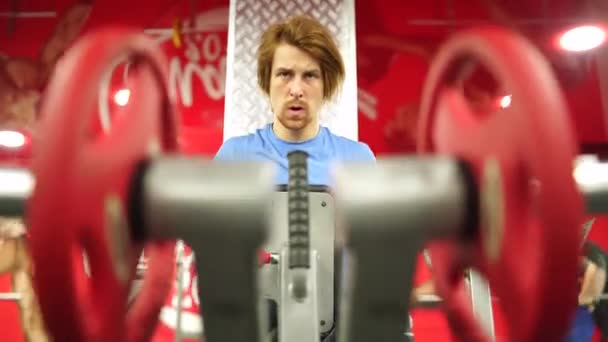Roodharige man werkte het trainingstoestel uit in de rode gym.close-up — Stockvideo