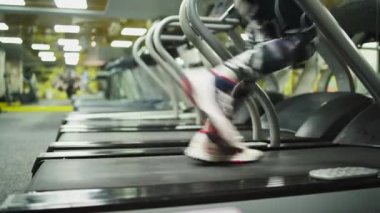 Spor salonunda koşu bandı. Spor adamı. Çerçevede perspektif.