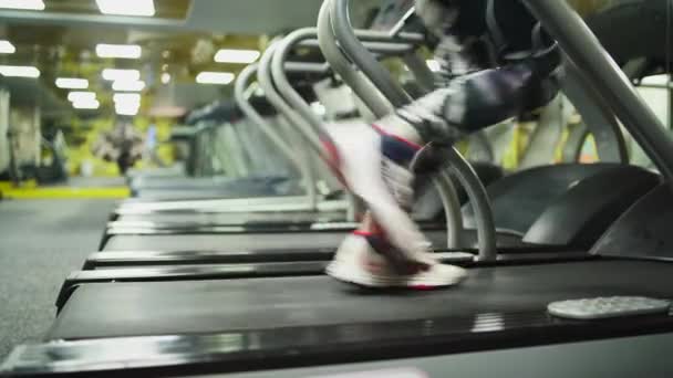 Close-up lopende man.treadmill in gym.guy in sport wear.perspective in frame — Stockvideo