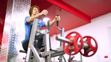 Kızıl saçlı adam, kırmızı spor salonundaki antrenman aletlerini halletti.