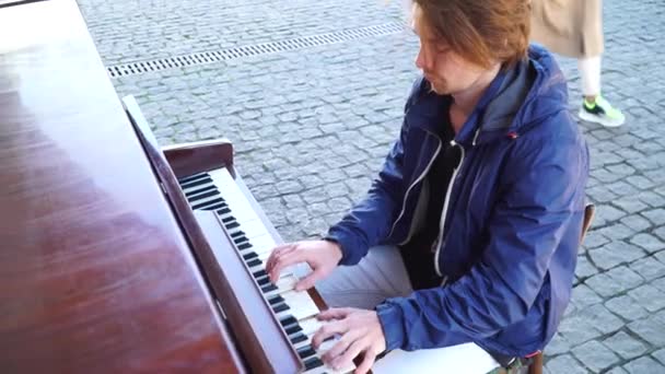 Tipul cu părul roșu cântând la pian într-o jachetă albastră pe stradă — Videoclip de stoc