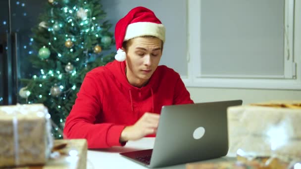 Homme travaille à l'ordinateur travaille pendant les vacances. Travailleur dans Santa Claus chapeau — Video