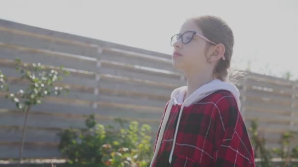 Portrét malé holčičky s brýlemi.školačka při východu slunce — Stock video
