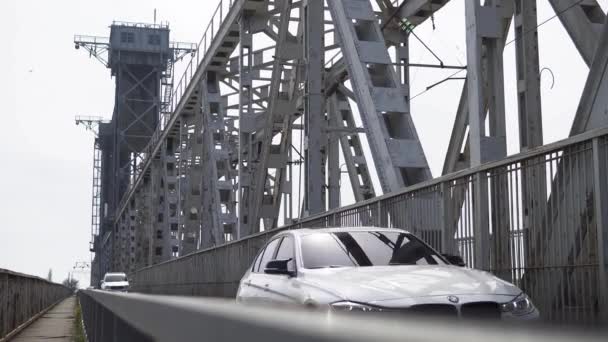 Construcción de hierro con nubes blancas.conducción bajo puente bridge.view desde abajo — Vídeos de Stock