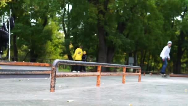 Skater practicando en skate park, haciendo tricks.sliding a bordo en barandilla larga — Vídeo de stock