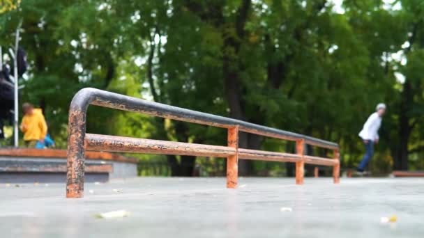 Patineur pratiquant dans le skate park, faisant des tricks.sliding à bord sur une longue rampe — Video