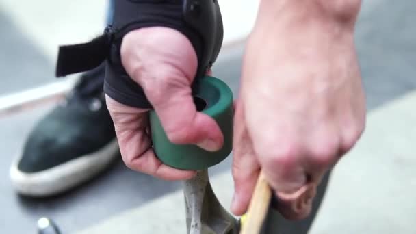 Close-up van hoe de handen het turquoise wiel van het skateboard verwijderen — Stockvideo