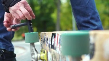 Yapıştırmalarla kaykay kaykayından çıkan renkli bir tekerleği nasıl büktüğünün yakın çekimi.