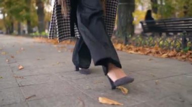 Ayakları siyah ayakkabılarla yakın plan. Yakından Afrikalı Amerikalı bir kadın yürüyor..