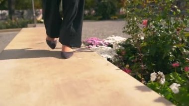 Topuklu ayakkabılı siyah bir kadın yürüyor. Yakından..