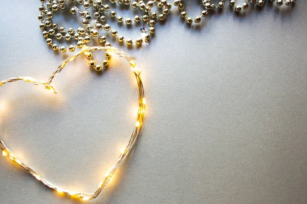 Gümüş bir arka planda LED yapılmış kalp ve noel boncukları