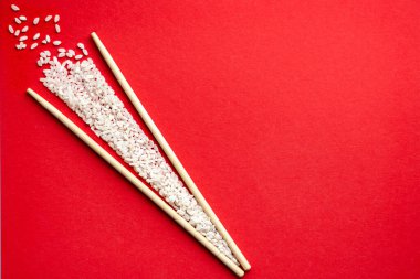 Kırmızı arka planda suşi bambu için ayağa kalk ve çubuklar hazırla.