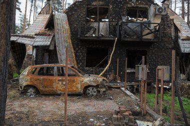 Ukrayna 'da savaş. Bir evin ve yanan bir arabanın kalıntıları. Bombalanmış bina..