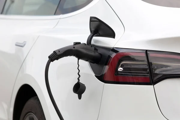 Charging electric car on the city street. Parking with charger.