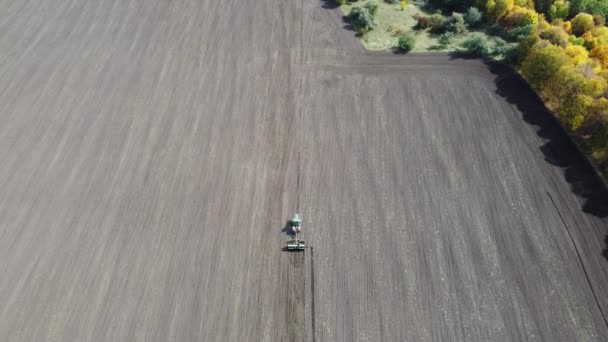 トラクターは現場で働いている 自然を背景に 環境シーン 農業農業の分野 緑の大地の質感 パノラマ映像 — ストック動画