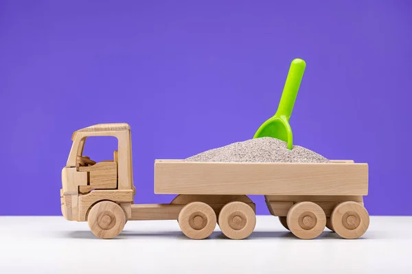 木制玩具卡车微型 装满了沙子 里面是一只绿色的鸭子 男孩的乐趣 紫丁香背景 — 图库照片