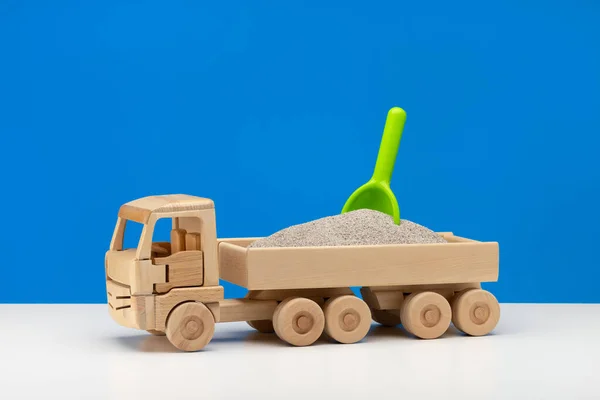 一辆装有绿色铲子的微型木制玩具车 男孩的乐趣 蓝色背景 — 图库照片