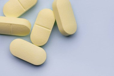 Gri arka planda birkaç sarı hap. Eczane. İlaçlar. Stüdyo görüntüsü, kopyalama alanı.