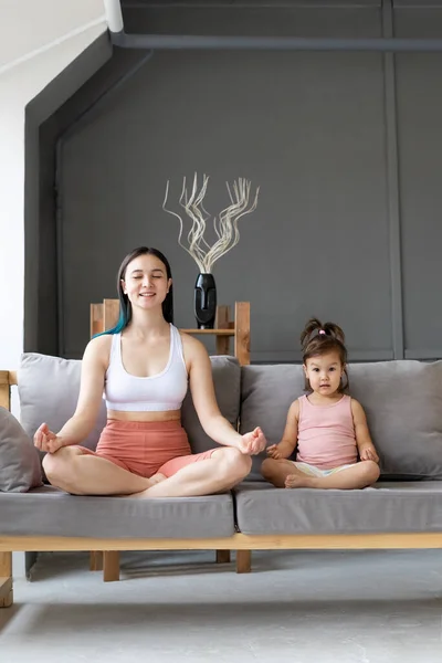 Joven Madre Con Pequeña Hija Sentada Posición Loto Sofá Meditación — Foto de Stock