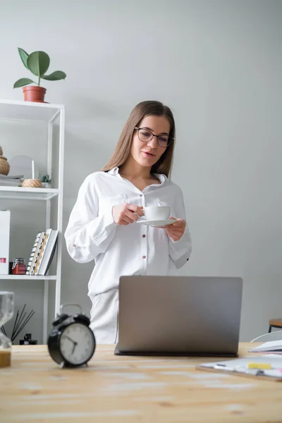 Donna Che Tiene Caffe Guardando Portatile Piedi Ufficio — Foto Stock