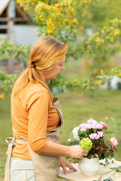 Roodharige Vrouw Oranje Trui Beige Schort Maakt Handgemaakt Boeket Tafel — Stockfoto