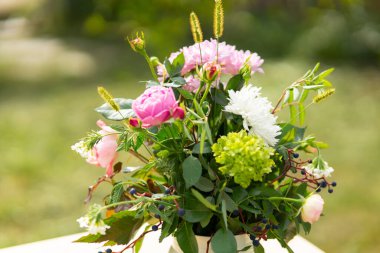 Ev bahçesindeki bir saksıda el yapımı çiçek buketi. Yeşil doğal arkaplan.