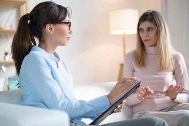 Hasta sorunlarını ofiste oturan psikoterapistle konuşuyor..