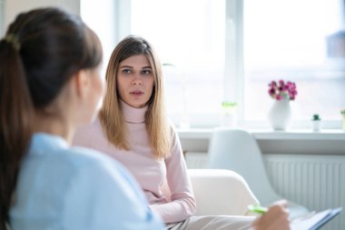 Hasta sorunlarını ofiste oturan psikoterapistle konuşuyor..