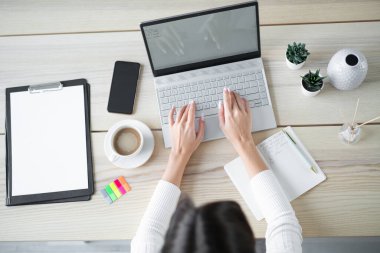 Dizüstü bilgisayarda yazı yazan genç bir kadın, üst görünüm.