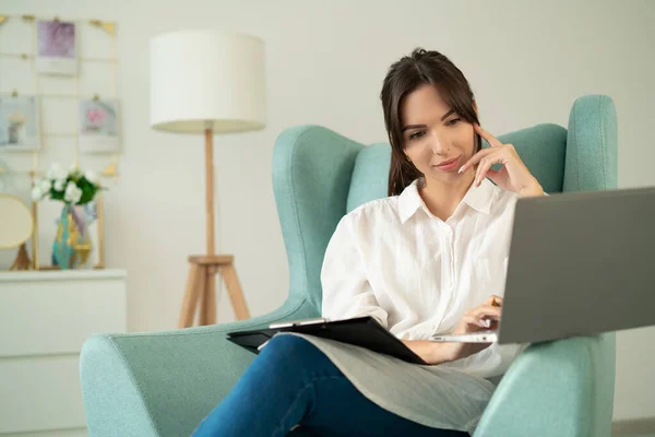 Jovem Mulher Usando Seu Laptop Casa Enquanto Sentada Poltrona — Fotografia de Stock