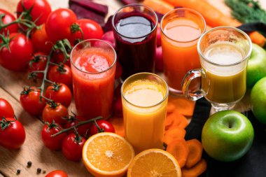Sarı suyu olan bir bardağa yakın plan. Taze sıkılmış meyve suları çiftlik sebzeleri ve ahşap kırsal masada meyveler. Vitamin yaz diyeti.