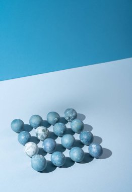 Mavi renkli yumurtalar açık mavi arka planda dikdörtgen şeklinde dizilmiş..