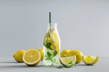Nane aromalı detoks suyu, gri arka planda limon. Citrus limonatası. Yaz meyveli su. Ev yapımı kokteyl tazeleniyor.