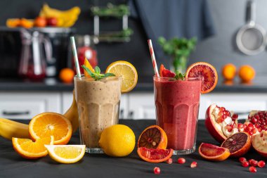 Sağlıklı iştah açıcı kırmızı ve sarı smoothie tatlı bardaklar, mutfak arka planı.