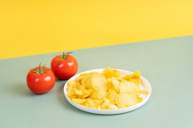 İki olgun domatesin yanında beyaz tabakta altın kırıntıları. Boşluğu kopyala.