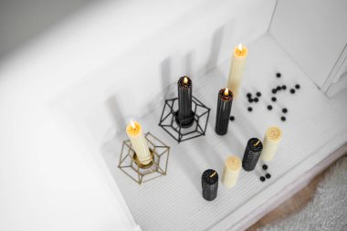 Burning hand wax candles in decorative fireplace. Romantic atmosphere. Top view. clipart