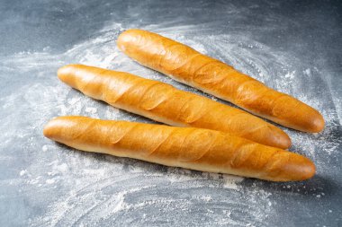 Gri arka planda unlu Fransız ekmeği. Fransız ekmeği. Geleneksel Fransız yemekleri.