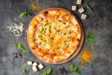 Koyu arkaplanda nefis İtalyan peynirli pizza. Malzemelerle birlikte. Geleneksel İtalyan yemekleri. Üst görünüm.