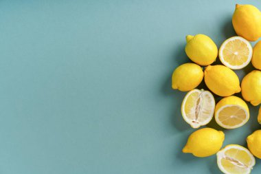 Yeşil kati arka planda taze sarı limonlar, sağlıklı yaşam tarzı ve minimalizm kavramı..