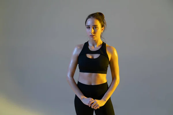 Νεαρή Γυναίκα Στέκεται Αθλητικά Μαύρα Ρούχα Στο Στούντιο Νέον Φως — Φωτογραφία Αρχείου