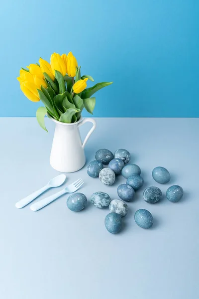 Kruik Met Gele Tulpen Paaseieren Lepel Vork Blauwe Achtergrond Plaats — Stockfoto