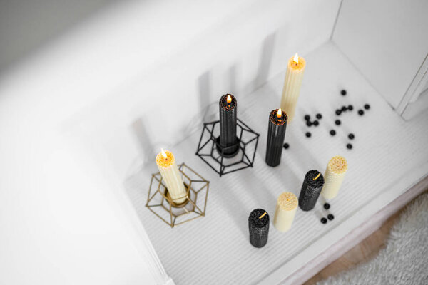 Burning hand wax candles in decorative fireplace. Romantic atmosphere. Top view.