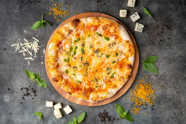 Koyu arkaplanda nefis İtalyan peynirli pizza. Malzemelerle birlikte. Geleneksel İtalyan yemekleri. Üst görünüm.