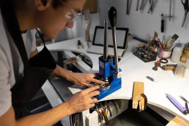 Yüzüğe yakın çekim. Yüzüğü büyütmek ve küçültmek için bir mücevher. Adam yüzük takmaya çalışıyor. Bulanık arkaplan.