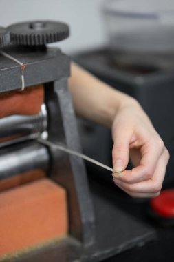 Gümüş bir boşluk olan bir elin yakın çekimi. Yuvarlak gümüş. Basın toplantısı.